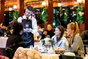 a man standing in a restaurant with people sitting at tables at Bosphorus Tour Organization in Istanbul