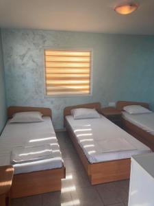 two beds in a room with a window at Бунгала в Поморие in Pomorie +10 photos