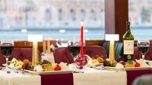 a table with two plates of food and wine glasses at Bosphorus Tour Organization in Istanbul