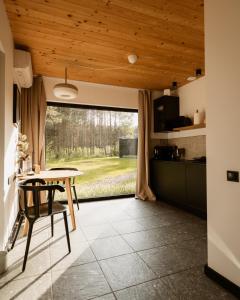 a kitchen and dining room with a table and a window at w lesie in Skrwilno
