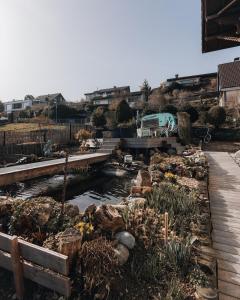 a garden with a pond and a wooden walkway at LaVida Panorama Thunersee, Wellness Oasis, Mountains in Thun