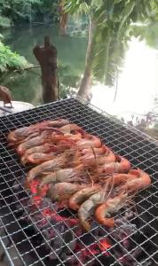 a group of food cooking on a grill at ริมแควโฮมสเตย์ กาญจนบุรี in Ban Pong Pat