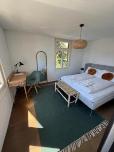 a bedroom with a bed and a table and a mirror at LaVida Panorama Thunersee, Wellness Oasis, Mountains in Thun