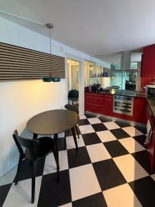 a kitchen with a table and a checkered floor at LaVida Panorama Thunersee, Wellness Oasis, Mountains in Thun