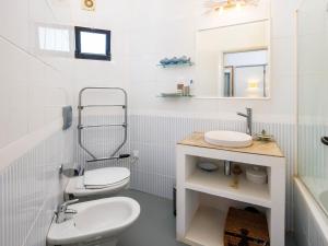 a white bathroom with a toilet and a sink at Villa Sunshine in Vale do Lobo