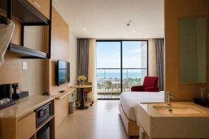 a hotel room with a bed and a sink and a television at Lagoon Beach Of The Arena Cam Ranh - Free room upgrade in Cam Ranh International Airport