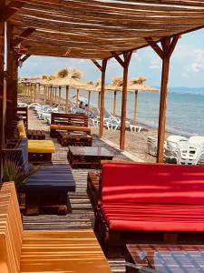 a wooden deck with chairs and tables on the beach at Бунгала в Поморие in Pomorie