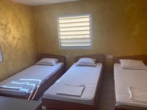 two twin beds in a room with a window at Бунгала в Поморие in Pomorie