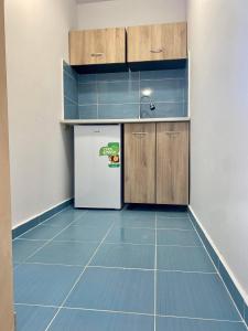 a kitchen with blue tile floors and a refrigerator at Бунгала в Поморие in Pomorie