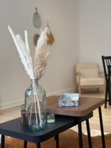 a glass vase on a table with feathers in it at Le Commerce-Gare-Centre-Ville in Montbéliard +12 photos
