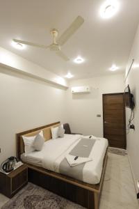 a bedroom with a bed with a laptop on it at Hotel Pearl -Jaipur Pink City Centre in Jaipur
