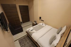 a bedroom with a bed with a laptop on it at Hotel Pearl -Jaipur Pink City Centre in Jaipur