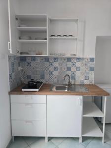 a kitchen with white cabinets and a sink at Hotel Villa Cecilia in Ischia Town +63 photos