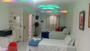a room with two beds and a bathroom with a sink at Apartamento A 43 Flat Centro in Mogi das Cruzes