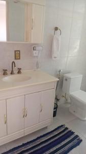 a white bathroom with a sink and a toilet at Apartamento A 43 Flat Centro in Mogi das Cruzes +20 photos