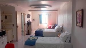 a hotel room with two beds and a bathroom at Apartamento A 43 Flat Centro in Mogi das Cruzes