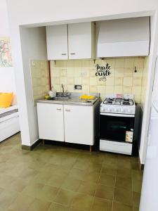 a small kitchen with a stove and a sink at depto "A" 1 dormitorio centro in Trelew +3 photos