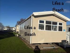 a mobile home with the words life is a beach at Lifes a Beach on Presthaven Sands in Prestatyn