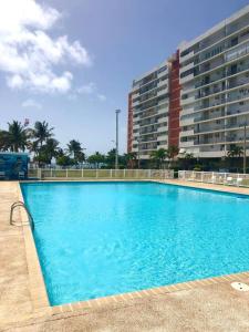 a large blue swimming pool in front of a building at Private Island Oceanview Condo in Fajardo