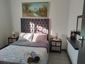 a bedroom with a bed with towels on it at Kosies Nest Gastehuis in Cape Town
