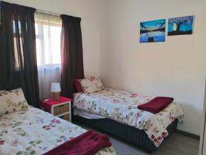a bedroom with two beds and a window at Kosies Nest Gastehuis in Cape Town