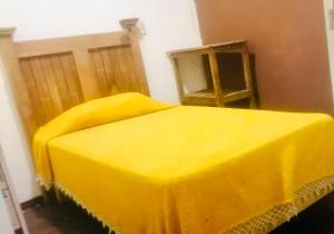 a bedroom with a yellow cover on a bed at Hostal Queretaro LOMAS M in Laborcillas
