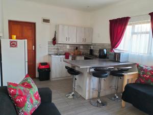 a kitchen with a counter and some chairs in a room at Kosies Nest Gastehuis in Cape Town