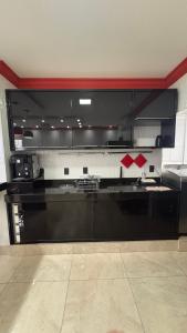 a large kitchen with black cabinets and appliances at Izze Home in Palmas