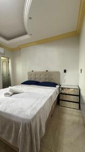 a bedroom with a large white bed in a room at Izze Home in Palmas
