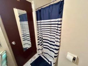 a bathroom with a shower with a blue and white shower curtain at Luxury Oasis Villa in Silver Sands