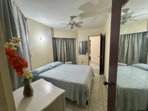 a bedroom with two beds and a vase of flowers on a table at Luxury Oasis Villa in Silver Sands