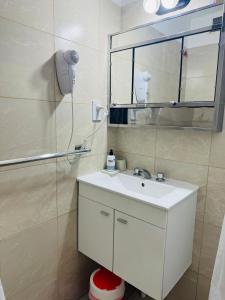 a bathroom with a white sink and a mirror at depto "A" 1 dormitorio centro in Trelew