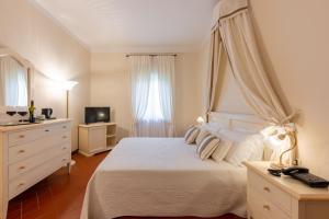 a bedroom with a white bed and a television at Tenuta Quadrifoglio in Gambassi Terme +73 photos