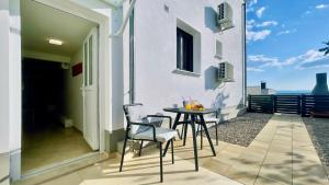 a patio with a table and chairs on a balcony at Mini Lea in Jadranovo