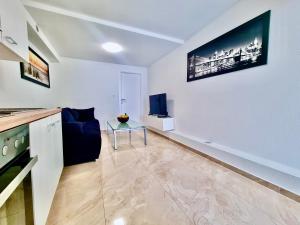a living room with a blue couch and a tv on a wall at Mini Lea in Jadranovo
