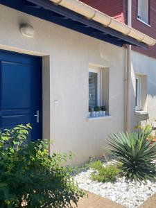 a blue door on the side of a house with plants at Domaine du Malda Côte Basque in Anglet