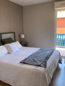 a bedroom with a large white bed with a window at Domaine du Malda Côte Basque in Anglet