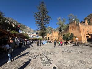 a group of people walking down a street with a star on the ground at Dar Nomads in Chefchaouen
