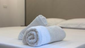 a towel sitting on top of a bed at Eden Rooms in Vlorë +49 photos