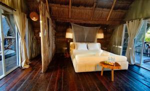 a bedroom with a white bed and a table at Hotel Boutique Sylvie in Mahahual