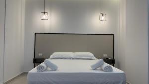a bedroom with a white bed with two pillows at Eden Rooms in Vlorë