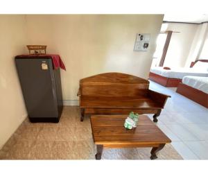 a living room with a piano and a table at Johnny Guesthoues and Restaurant in Ban Donsôm Tai