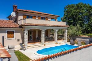 a house with a swimming pool in front of it at Villa Antonela in Divšići
