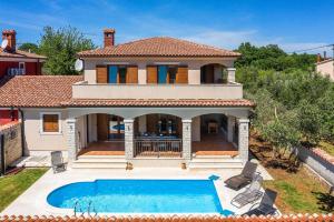 a house with a swimming pool in front of it at Villa Antonela in Divšići