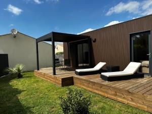 a wooden deck with two chairs and a gazebo at Lilikaz in Saint-Laurent-de-la-Prée