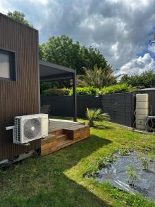 a backyard with a wooden deck with a air conditioner at Lilikaz in Saint-Laurent-de-la-Prée