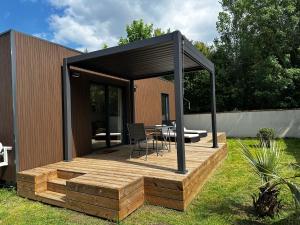 a house with a wooden deck with a table at Lilikaz in Saint-Laurent-de-la-Prée +4 photos