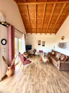 a living room with a couch and a wooden ceiling at Blue Waves House 2 in Soroni