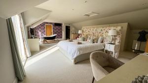a bedroom with a large bed and a chair at Gorse Lodge Lakeside & Courtyard in Stubton