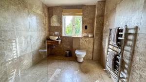 a bathroom with a toilet and a sink and a window at Gorse Lodge Lakeside & Courtyard in Stubton +86 photos